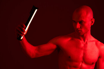 Striking black and white image of a focused man holding a flashlight, creating dramatic lighting...