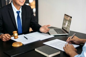 A man in a suit is holding a gavel and talking to another man