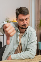 Dislike. Upset unhappy man showing thumbs down sign gesture, expressing discontent, disapproval...