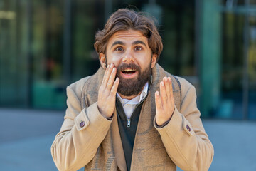 Oh my God, Wow. Indian young businessman looking surprised at camera with big open eyes shocked by...