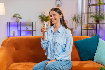 Thirsty woman hold glass of natural filtered aqua make sips drinking still water preventing...