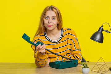 Call me. Woman looking at camera advertising phone call having conversation on wired old-fashioned...