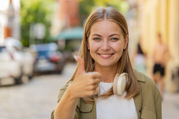 Like. Happy Caucasian woman looking approvingly at camera showing thumbs up like sign positive...