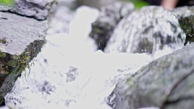 Pov close-up of fresh mountain water cascading off a rocky cliff in Karnataka's Western Ghats