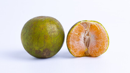 Fresh greenish yellow orange fruit and peeled tangerine with juicy orange pulp isolated on white background. Tropical citrus fruit rich in vitamin C, healthy snack, organic food concept.
