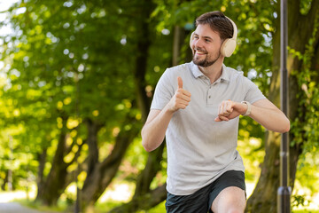 Runner starting smart watch timer and running. Man checking heart rate monitor before jogging. Male...