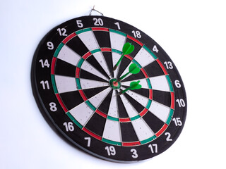 Dartboard with three green darts hitting bullseye on white isolated background. Target accuracy,...