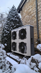 Heat pump unit outside stone house in snowy winter garden