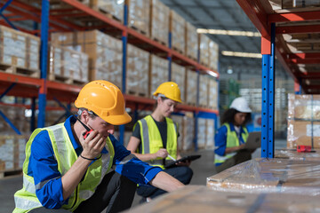 Warehouse, worker and working concept. Male warehouse worker working and management by radio walkie talkie in warehouse