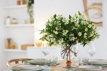 Bouquet of beautiful jasmine flowers on dining table indoors. Space for text