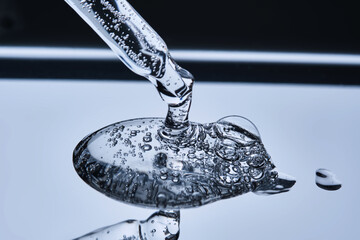 The texture of serum with spicules in a dropper on a blue background.