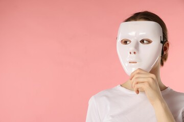 Anonymity. Woman wearing mask on pink background, space for text