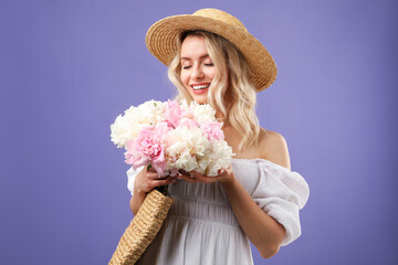 Happy woman with bouquet of beautiful peonies on purple background