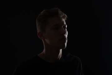 Anonymity. Portrait of young man in darkness