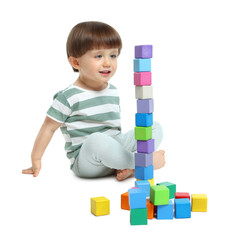 Cute little child playing with colorful cubes on white background