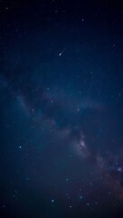 Obraz premium A meteor streaks across a vast star filled night sky with visible milky way