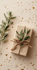 Eco-friendly gift box, adorned with olive sprigs and twine, rests on a beige surface scattered with gold stars