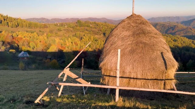 Ukraine, drone, flight in the Carpathians early in the autumn morning at sunrise near the city of Kosiv. Bright forests and dwellings of the Hutsul highlanders on the glades