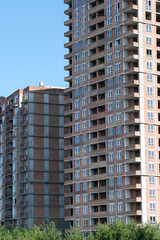 Fototapeta premium New residential buildings rise against a clear blue sky in the city