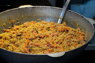 Deliciously fragrant rice dish prepared in a large pan at sunset