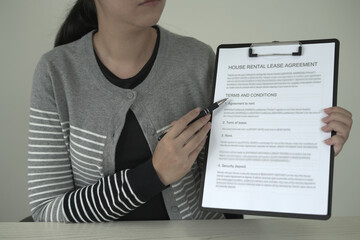 A real estate agent is explaining the terms and conditions of the lease agreement to tenant and...