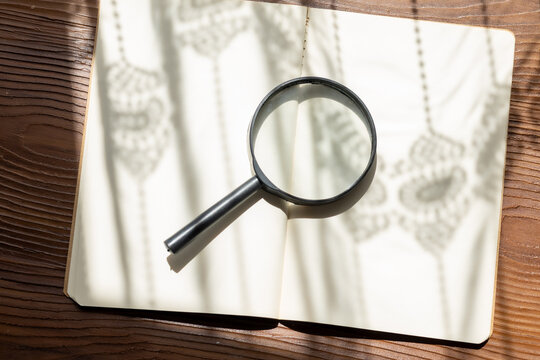 old book and magnifying glass close up