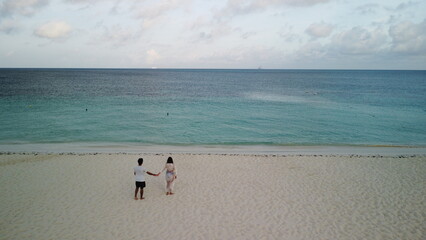 couple holding hands in the beach