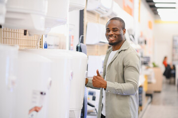 Customer choosing water heater in electronics store appliance section