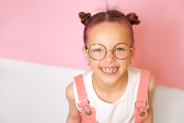 A laughing little cute girl wearing round-rimmed glasses. Vision correction in clinics. Children's...