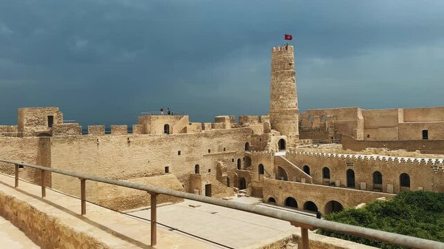 Historic Ribat fortress with tower and flag in Monastir, Tunisia under stormy skies