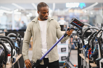 Man evaluating vacuum cleaner in electronics store