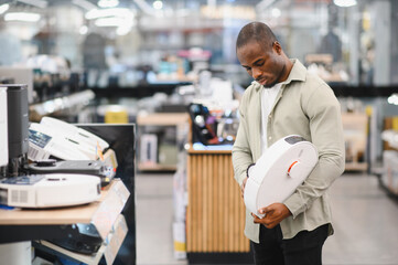 Customer choosing robotic vacuum cleaner in electronics store