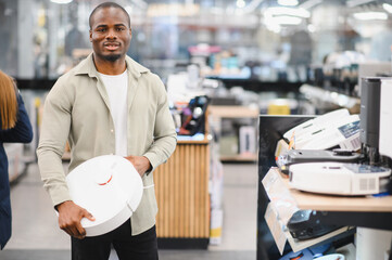 Customer choosing robotic vacuum cleaner in electronics store