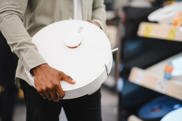 Customer choosing robotic vacuum cleaner in electronics store