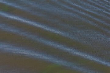 Calm water surface reveals gentle ripples during golden hour