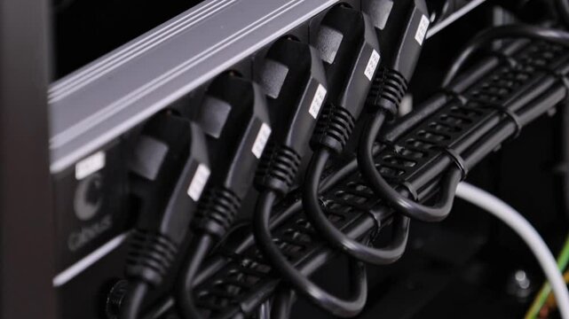 Telecommunications rack of network equipment with an uninterruptible power supply and multimedia equipment. View of the connection of the units. 