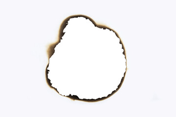 Burnt hole in a white paper sheet creating a grunge frame with scorched edges from fire. Vintage abstract design element for text or photos. isolated on white background with clipping path.