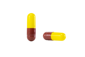 Yellow and brown medicine capsules. Pharmaceutical drug, antibiotic, or vitamin supplement for healthcare. isolated on white background with clipping path.
