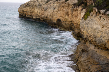 Obraz premium Stunning Torredembarra Lighthouse on rugged Mediterranean cliffs at Punta de la Galera, Tarragona, Catalonia. Perfect seaside nature and maritime beauty.