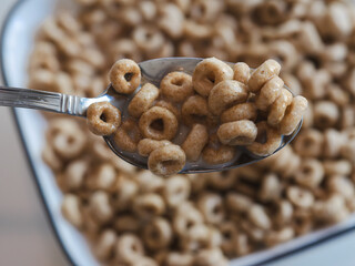 Spoonful of O Shaped Cereal with Milk Over a Bowl