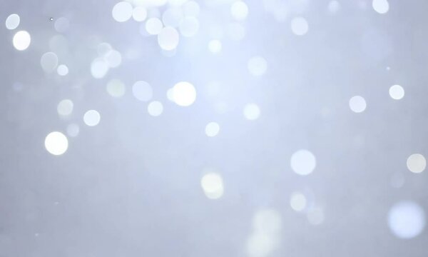 Silver bokeh lights twinkling across a white background with slow drifting sparkles and ambient shimmer