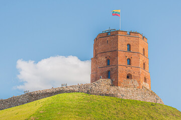 Gediminas Tower or Castle, the remaining part of the Upper Medieval Castle in Vilnius, Lithuania with Lithuanian flag on the top in a sunny day with blue sky on background