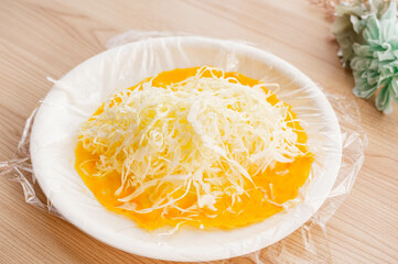 ラップにしいた卵に千切りキャベツを加える