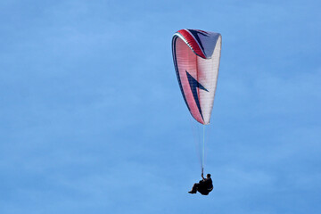 Paraglider flying in a blue sky	