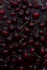 Background with ripe cherries in water with water drops