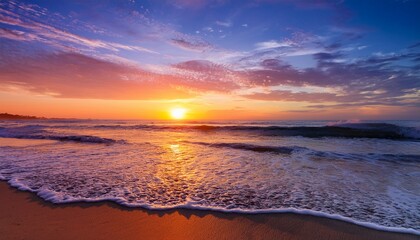 vibrant color sunset is enhanced by tranquil ocean as soft waves gently touch shore and sun descends beneath horizon