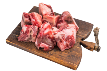 Raw diced Beef meat with bones for stew or goulash on wooden board isolated on white background. top view