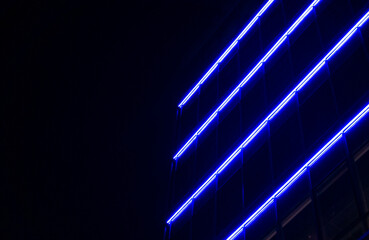 Modern building facade with glowing blue neon lights at night