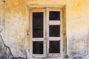Weathered wooden window stands against an old textured wall, adding rustic charm to architecture...