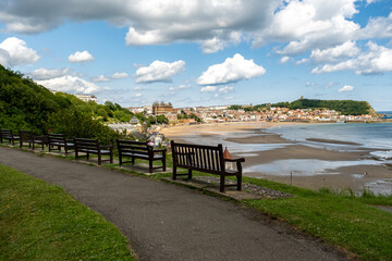 Fototapeta premium Wooden benches on the cliff overlooking Scarborough's South Bay